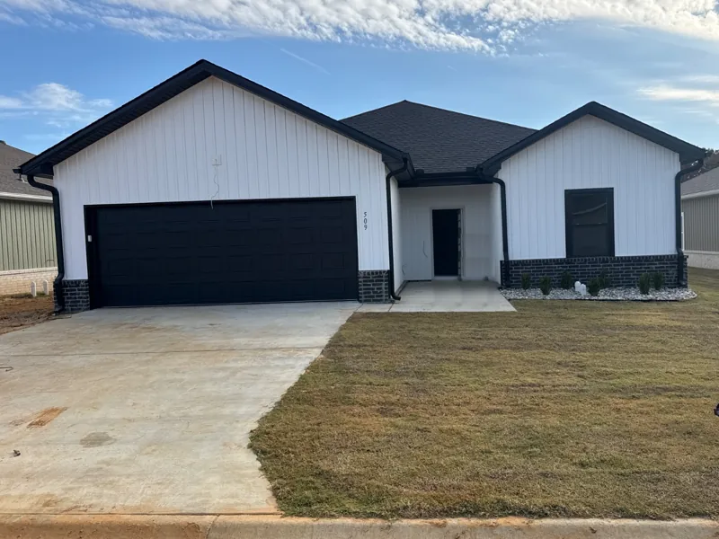 A white home with a black garage door on Fuji Drive